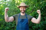 happy-strong-farmer-farmers-hat-apron-flexing-arms-farm-outdoors_474717-79152.jpg